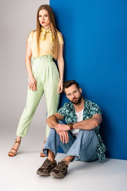 Gri ve mavi renkte yaz kıyafetleriyle poz veren güzel, şık bir çift. 