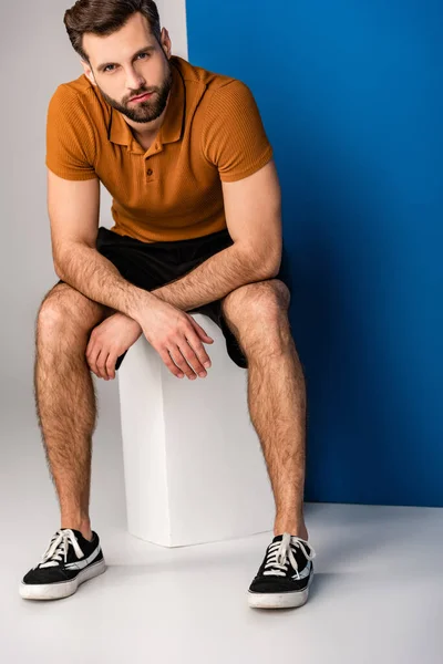 Stijlvolle Man Met Baard Korte Broek Bruine Polo Zittend Witte — Stockfoto