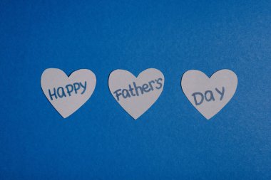 top view of grey paper crafted hearts with lettering happy fathers day on blue background clipart