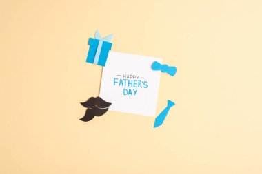 Top view of greeting card with lettering happy fathers day and decorative paper elements on beige background clipart
