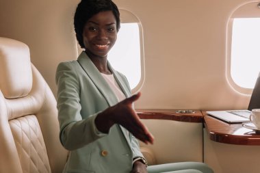 Mutlu Afro-Amerikalı iş kadını özel jetle selamlama jesti yapıyor.