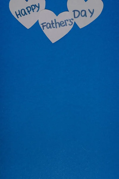 青い背景に幸せな父親の日の文字で心を作った灰色の紙のトップビュー — ストック写真