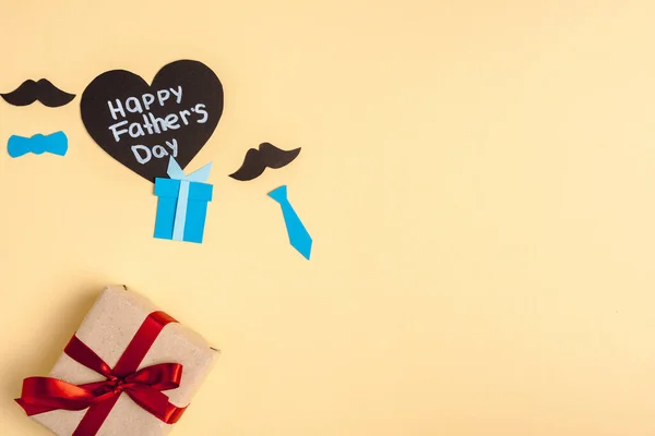 ギフトボックスのトップビュー 装飾紙の要素とグリーティングハート形のカードベージュの背景に幸せな父親の日をレタリング — ストック写真