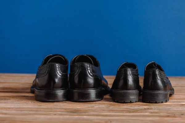 Black Mens Childrens Classic Shoes Wooden Surface Isolated Blue Fathers — Stock Photo, Image