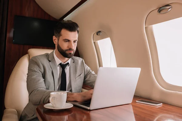 Serious Businessman Typing Laptop Cup Coffee Private Plane — Stock Photo, Image