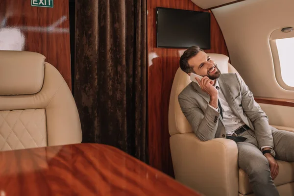 Улыбающийся Бизнесмен Разговаривает Смартфону Время Путешествия Частном Самолете — стоковое фото