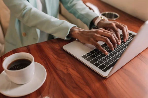 Vista Recortada Mujer Negocios Afroamericana Escribiendo Ordenador Portátil Cerca Taza — Foto de Stock