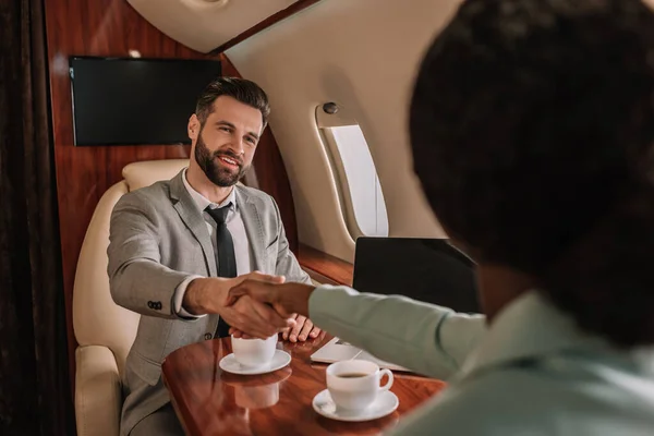 Selective Focus Smiling Businessman Shaking Hands African American Businesswoman Plane — Stock Photo, Image