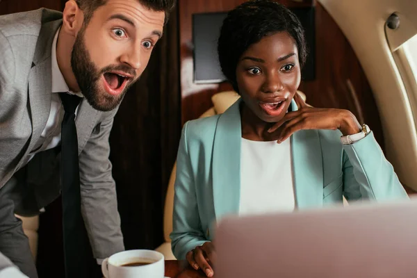 Selective Focus Shocked Multicultural Businesspeople Looking Laptop While Traveling Private — Stock Photo, Image