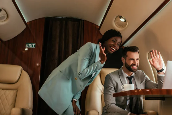 Smiling Multicultural Businesspeople Waving Hands While Having Video Call Laptop — Stock Photo, Image