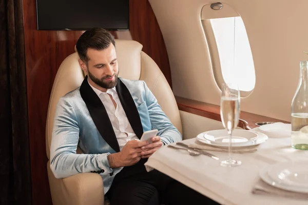 Homem Elegante Conversando Smartphone Enquanto Sentado Mesa Servida Jato Privado — Fotografia de Stock