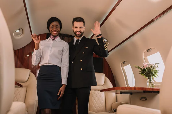 Gelukkig Piloot Glimlachende Afican Amerikaanse Stewardess Zwaaien Handen Terwijl Kijken — Stockfoto