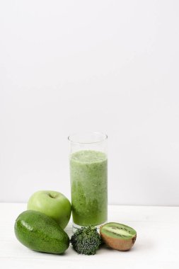 kivi, brokoli, avokado ve beyaz ahşap yüzeyde elmalı yeşil smoothie.