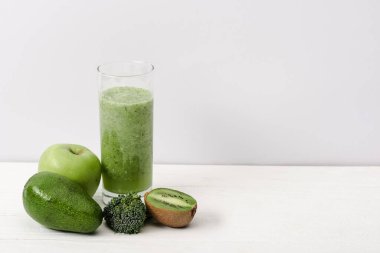 kivi, brokoli, avokado ve beyaz ahşap yüzeyde elmalı yeşil smoothie.