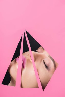 Pembe dudaklı ve kapalı gözlü bir kadın yüzü. Siyah arkaplanda delikler açıyor.