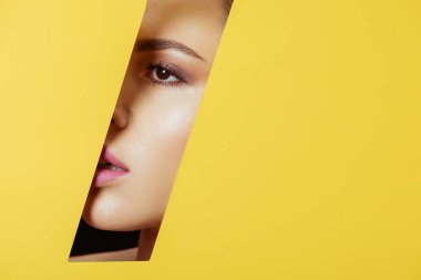 Woman looking across quadrangular hole in yellow paper clipart