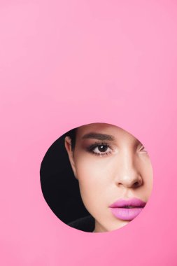 Duman gibi gözleri ve pembe dudakları olan güzel bir kız kara deliğin karşısındaki kameraya bakıyor.