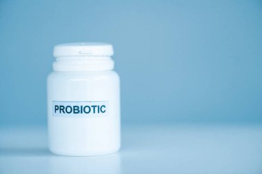 Mavi üzerine probiyotik harfler ve kopyalama alanı olan beyaz şişe
