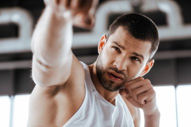 Spor merkezinde yumruklarını sıkmış yakışıklı dövüşçülerin seçici odağı. 