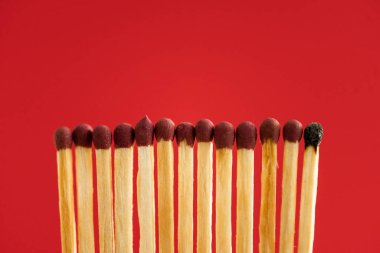 Burned match among another isolated on red clipart