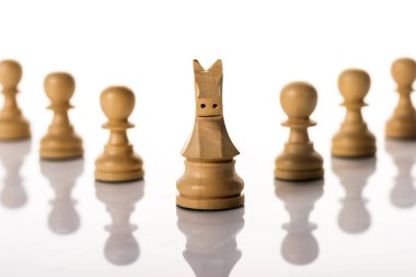 Selective focus of knight with pawns on white background clipart