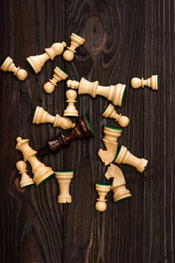 Top view of unique brown king among white chess pieces on wooden background clipart