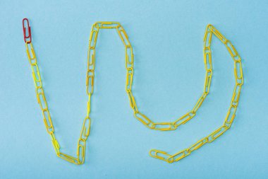 Top view of chain with unique red and yellow paper clips on blue clipart