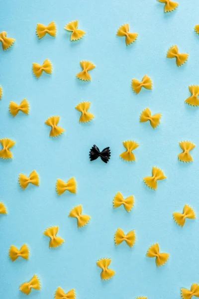 Plato Plano Con Pasta Negra Única Entre Amarillo Sobre Azul —  Fotos de Stock