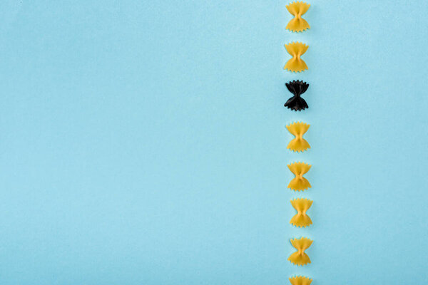 Вид сверху на черную пасту среди желтых и синих
 