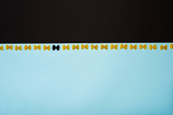 Top view of unique pasta among another on blue and black