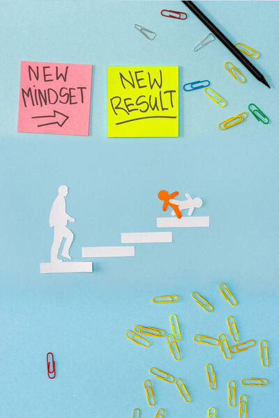 Top view of sticky notes with new mindset and new result lettering with paper clips, pencil and decorative men on career ladder on blue 