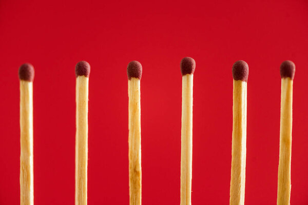 Line with wooden matchsticks isolated on red