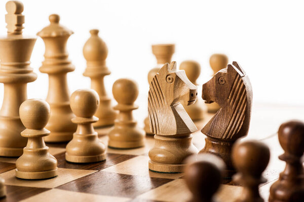 Выборочный фокус шахматных фигур на шахматной доске изолирован на белом
