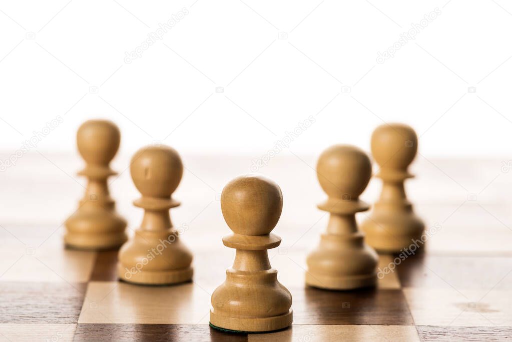 Selective focus of pawns on chessboard isolated on white