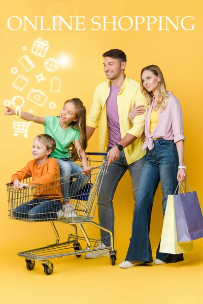 Parents Shopping Bags Kids Gesturing Sitting Shopping Cart Yellow Online — Stock Photo, Image