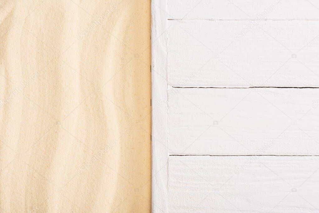 Top view of white wooden planks and sand