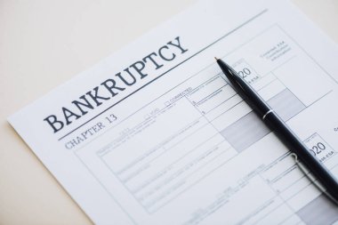 High angle view of pen on document with bankruptcy and chapter 13 lettering on white clipart