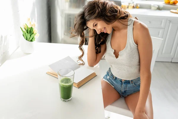 Attractive Girl Smiling While Reading Book Glass Smoothie Kitchen — ストック写真