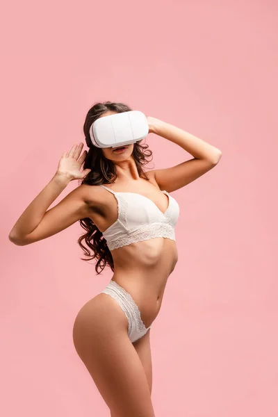 サイドビューのセクシー女の子とともに上げ手と仮想現実ヘッドセット孤立オンピンク — ストック写真