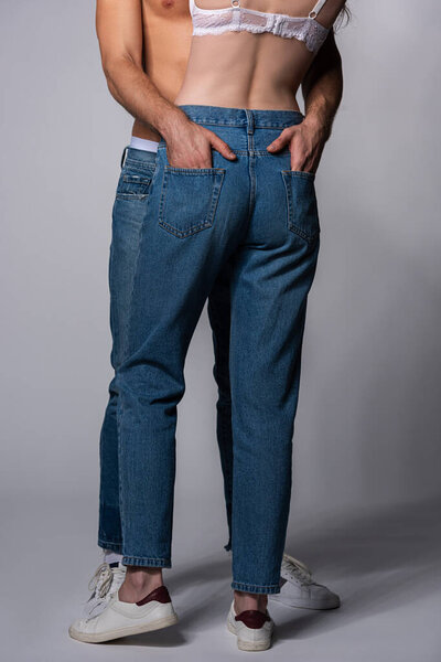 cropped view of man putting hands in pockets of girl on grey 