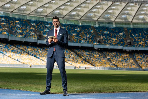 Smiling Young Businessman Suit Glasses Money Stadium — Stock Photo, Image