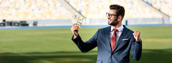 Sonriente Joven Hombre Negocios Traje Gafas Con Dinero Mostrando Gesto —  Fotos de Stock