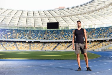 Stadyumda koşan yakışıklı genç sporcu.