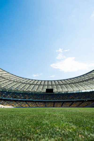 grassy football pitch at stadium at sunny day with blue sky