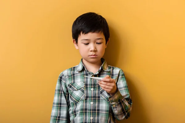 Cute Sad Asian Boy Looking Thermometer Yellow — Stock Photo, Image