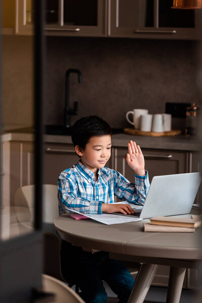 Мальчик, который учится онлайн с ноутбуком дома во время самоизоляции, избирательный фокус 