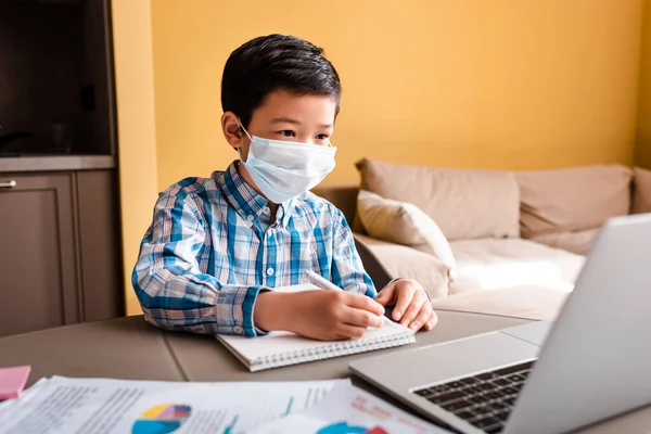 Băiat Asiatic Scris Mască Medicală Studiind Online Laptopul Acasă Timpul — Fotografie, imagine de stoc