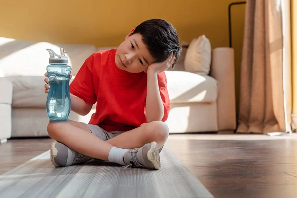 Bored Sportive Asian Boy Sports Bottle Sitting Fitness Mat Home — Stock Photo, Image