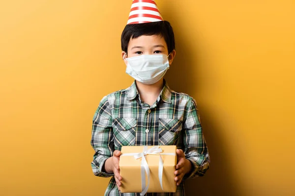 Azjatycki Chłopiec Stożek Party Maska Medyczna Gospodarstwa Urodziny Prezent Żółty — Zdjęcie stockowe