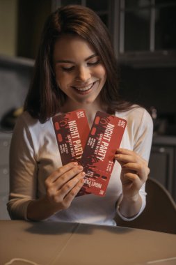 Gece parti biletleri tutan mutlu bir kadın, karantina konseptinin sonu. 